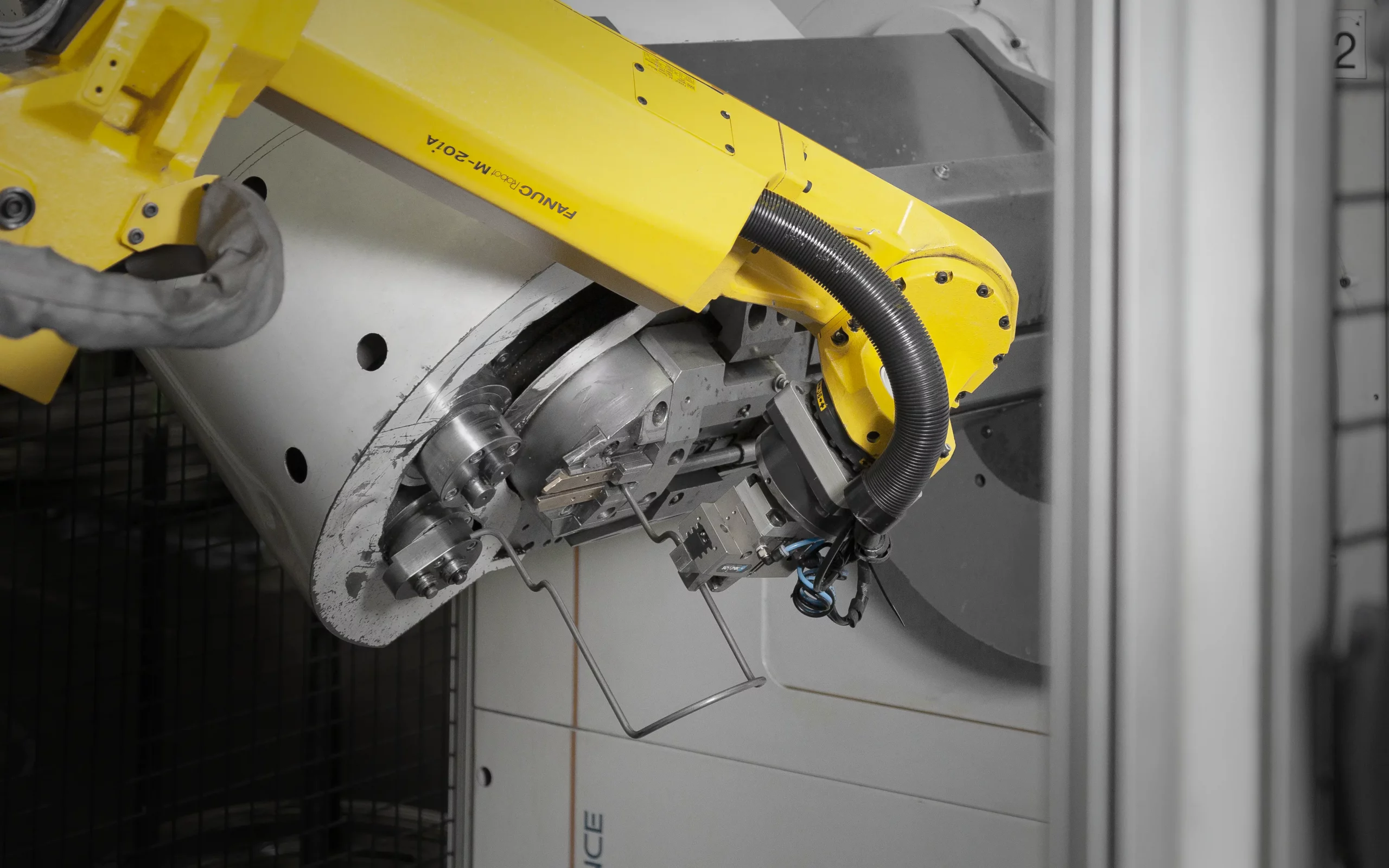 Industrieroboter bearbeitet eine Metallbaugruppe in einer Fertigungszelle.